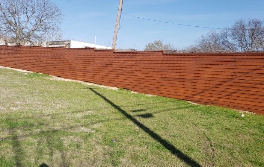 Wood fence in bright Austin summer sunlight